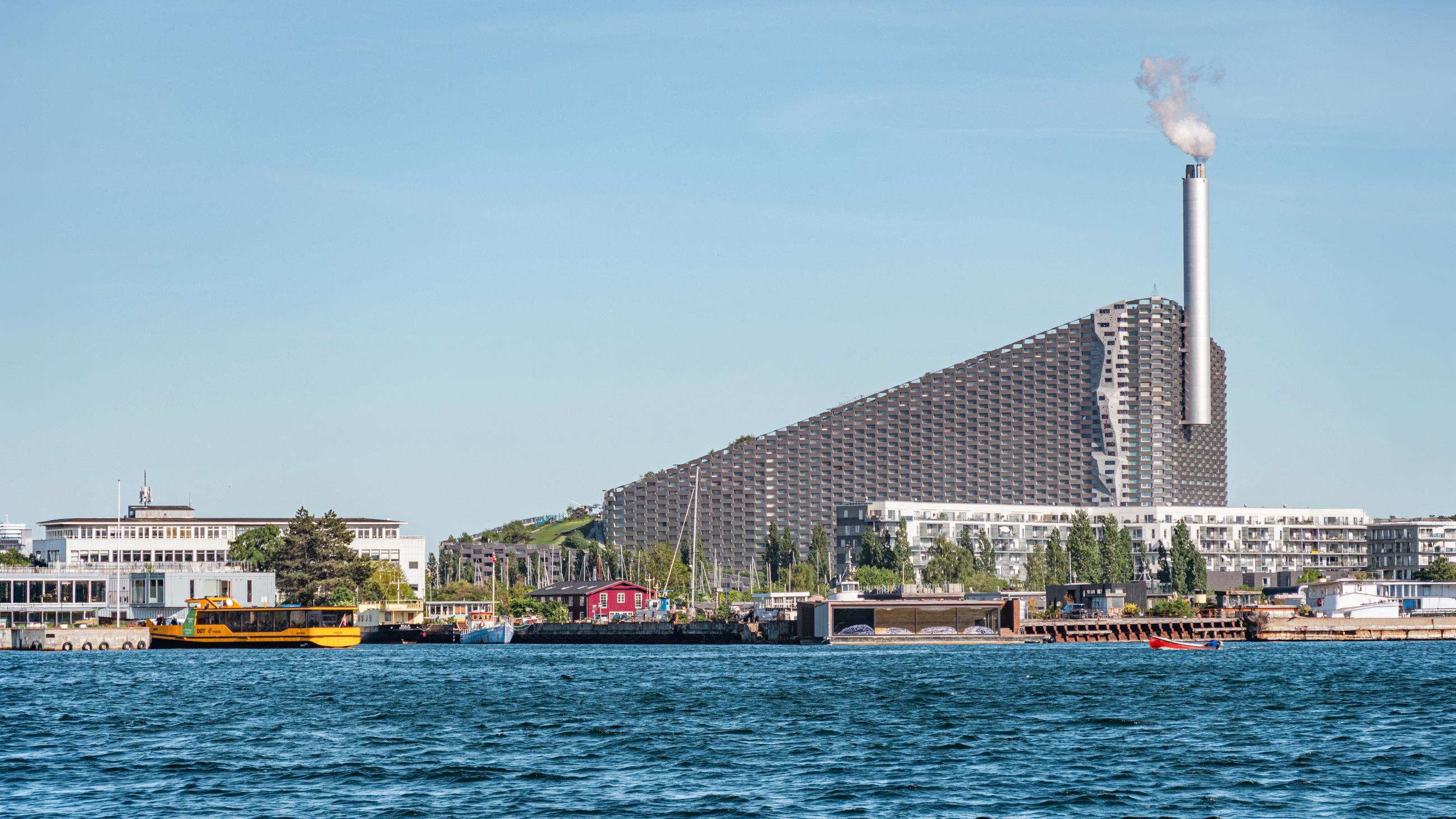 Incineration plant in the district of Amager, Copenhagen, Denmark, with modern buildings and boats