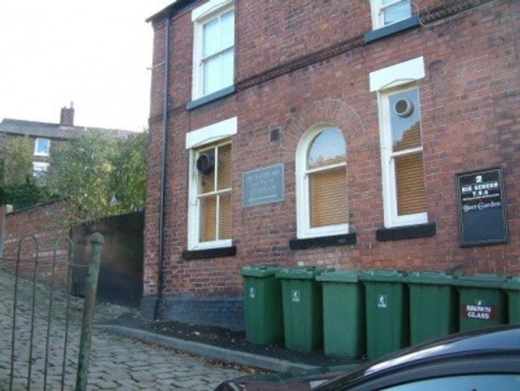 Green wheelie bins outside a hotel
