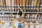 Woman in a refill shop, filling a container with lentils
