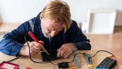 Man using soldering iron to repair electronic device