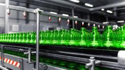 Green glass bottles in a factory on a conveyor belt 
