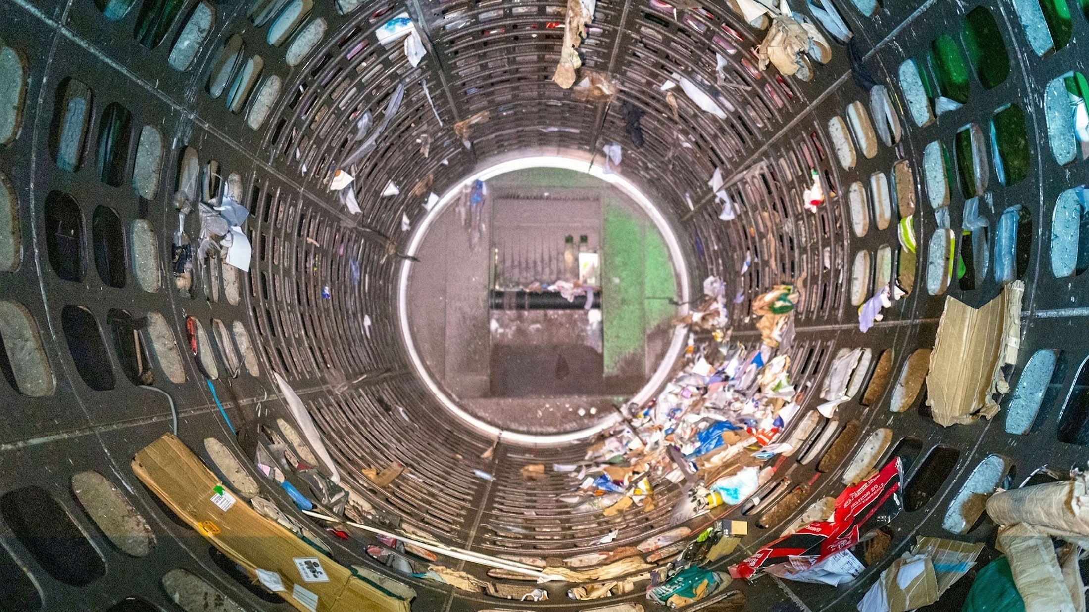 Photo looking inside a circular trommel screen with mixed household waste being spun