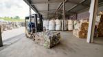 Bales of recyclable material in a warehouse, with forklift truck 