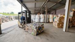Bales of recyclable material in a warehouse, with forklift truck 
