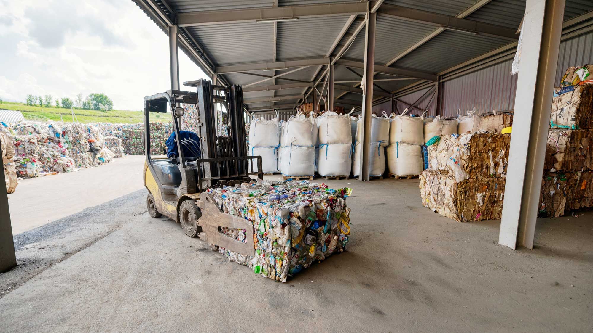 Bales of recyclable material in a warehouse, with forklift truck