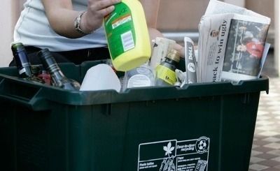 A person placing recycling in a bin