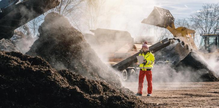 Woman in high-vis at an industrial composting site