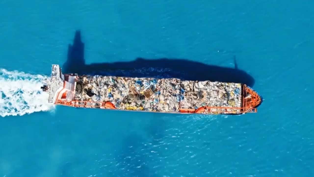 Aerial view of a ship carrying waste across the sea