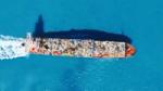 Aerial view of a ship carrying waste across the sea