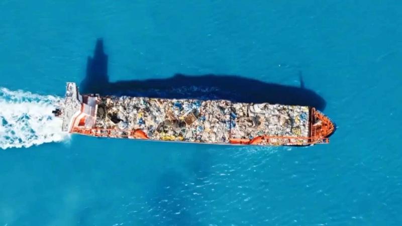 Aerial view of a ship carrying waste across the sea