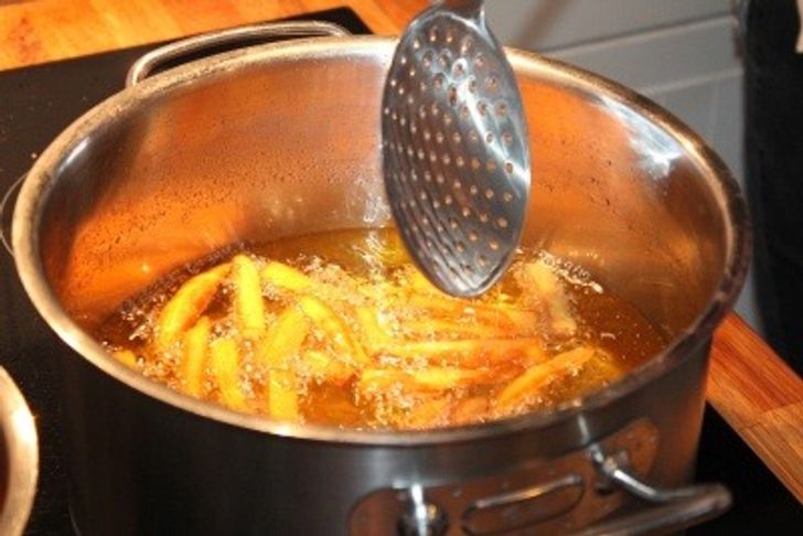 Chips cooking in a large pan of cooking oil