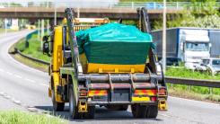 Skip truck transporting waste on a UK road