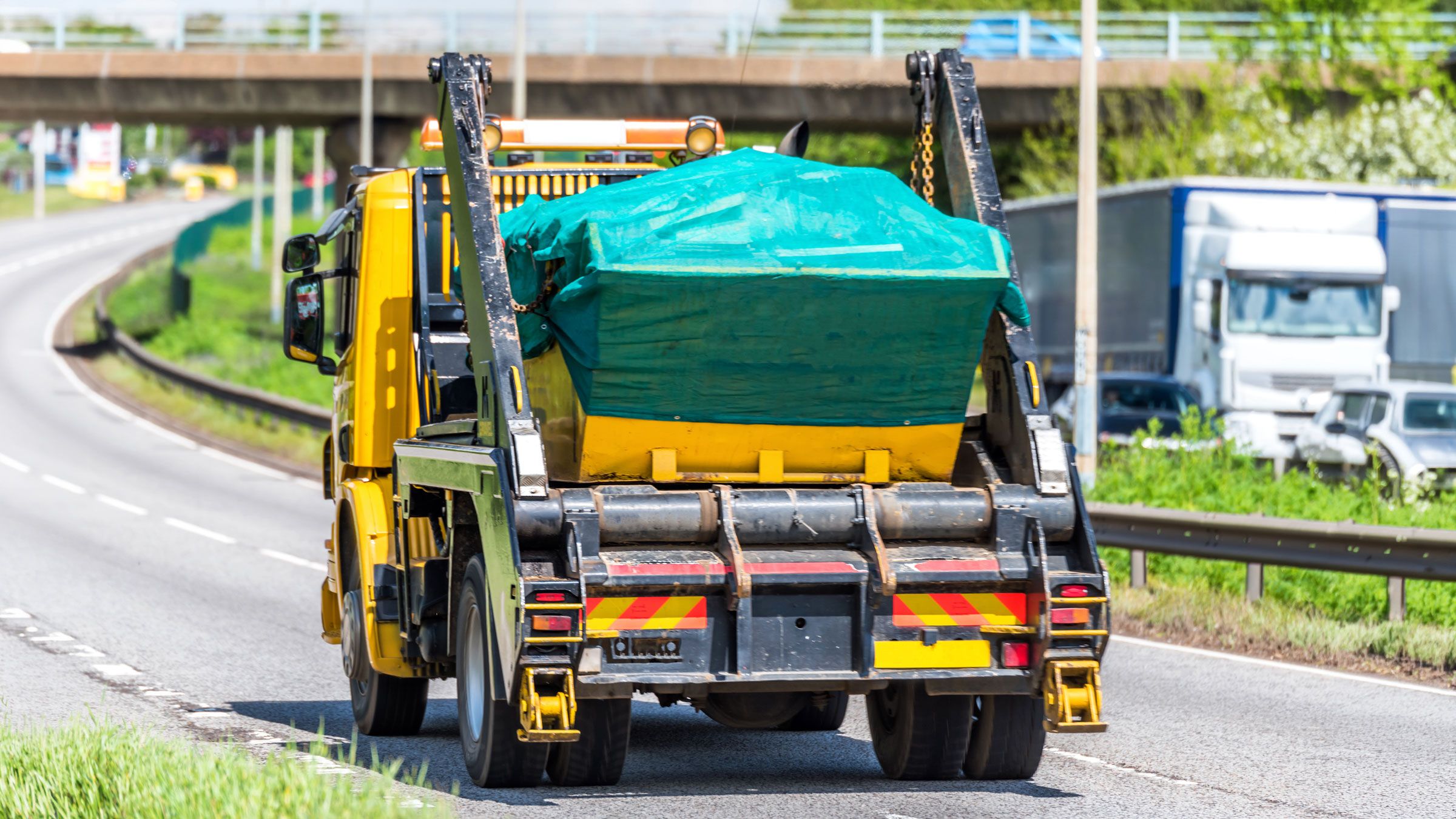 Skip truck transporting waste on a UK road