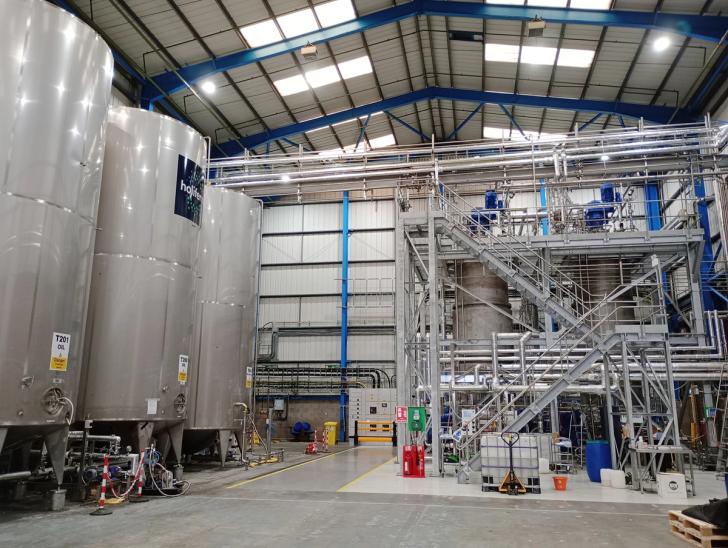 Interior photo of a biolubricant plant, with silver holding tanks and pipes