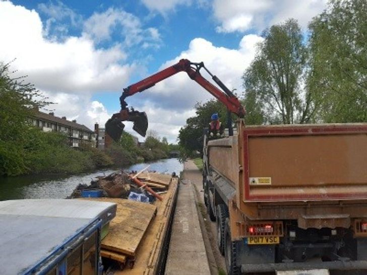 A machine collecting waste from a canal