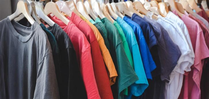 Hanging rail of used t-shirts of different colour