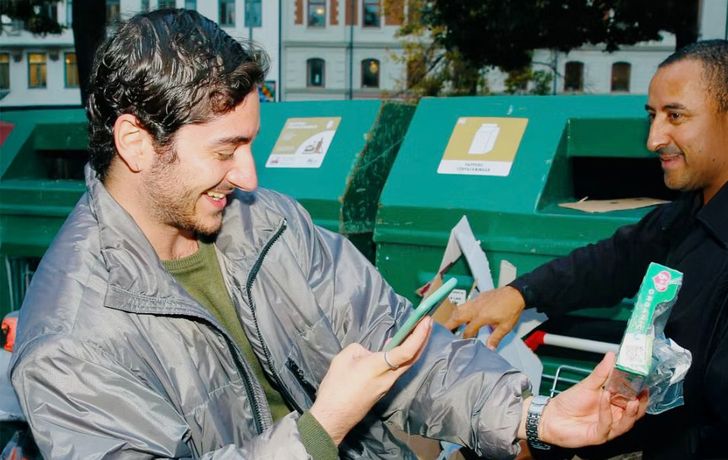 Man using smartphone app to use AI detection to claim a deposit on a returned paper coffee cup