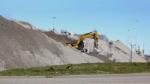 Piles of bottom ash from a waste recycling factory to be used in construction instead of sand.