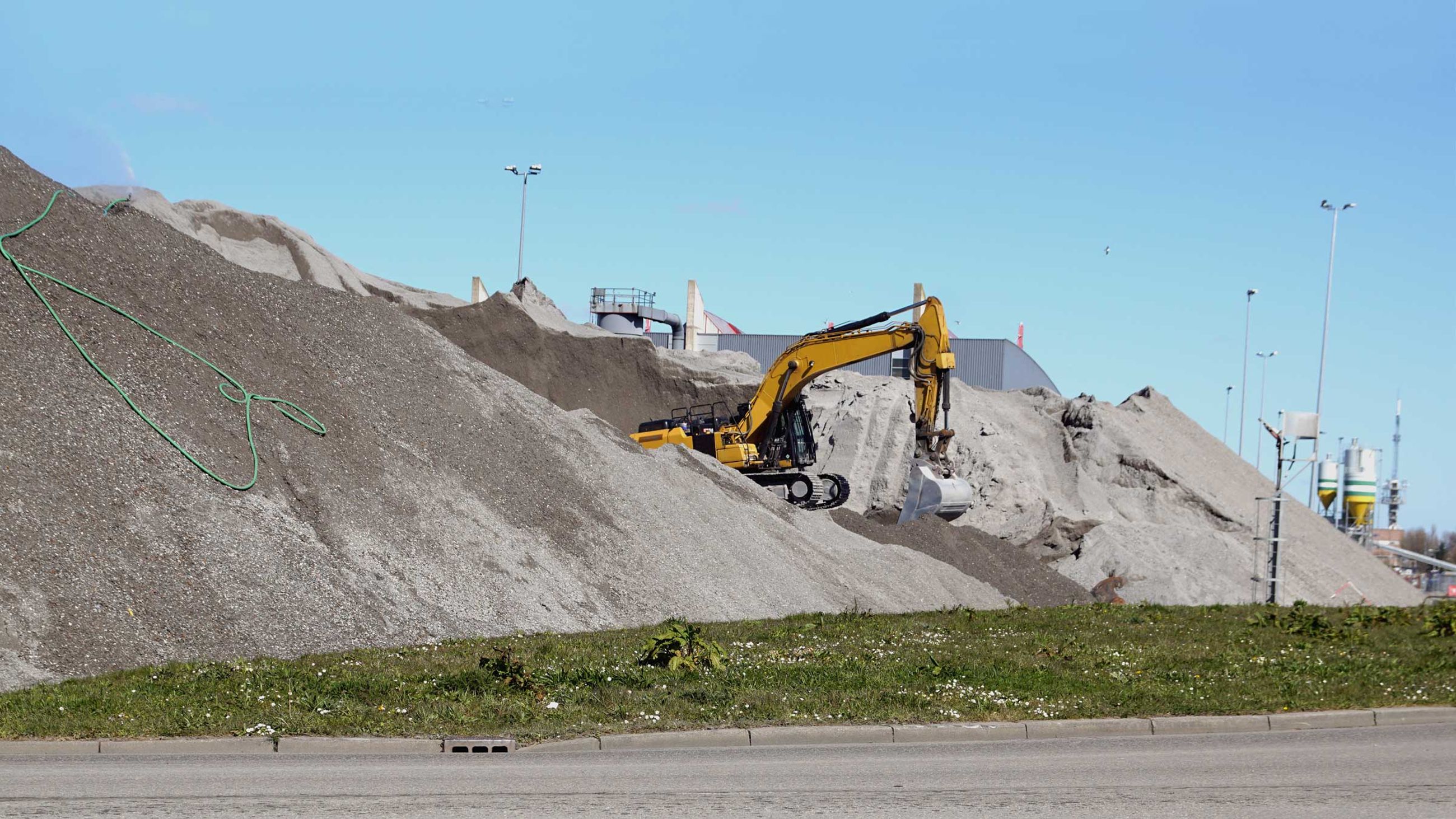 Piles of bottom ash from a waste recycling factory to be used in construction instead of sand.