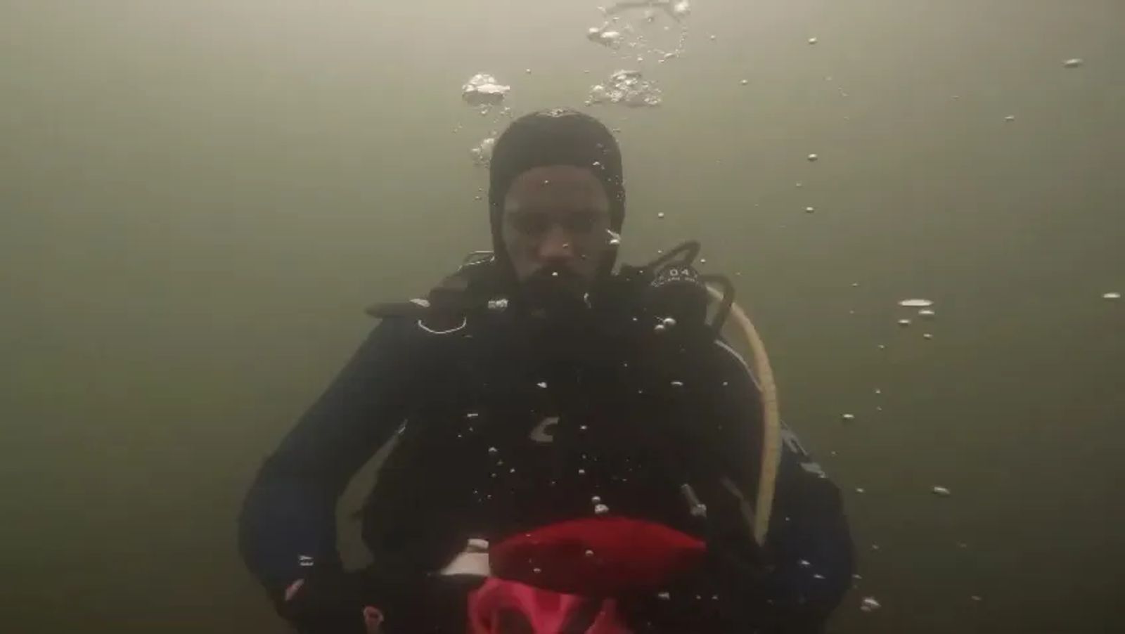 Mask removal drill underwater, mask off and held in both hands