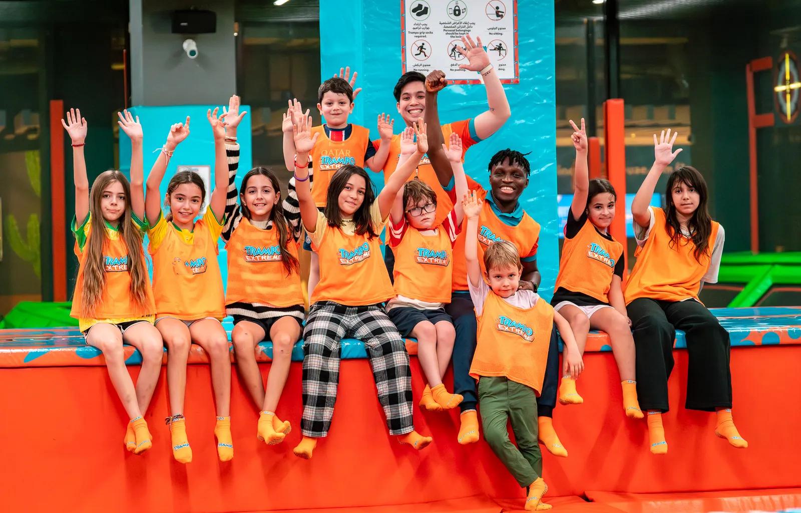 Kids with hands up at Trampo summer camp in Dubai