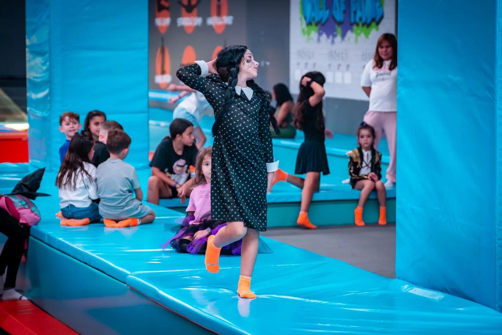 Child in costume jumping on the trampolines
