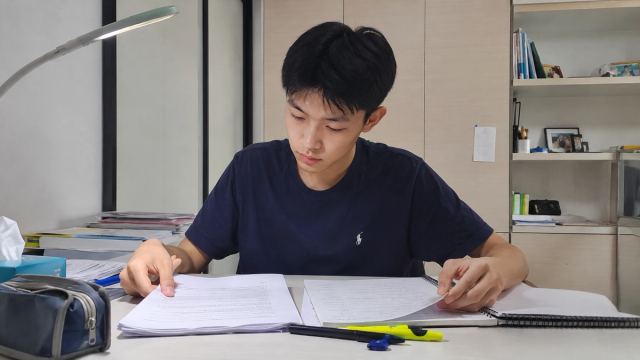 An O-Level English student comparing argumentative and discursive essay conclusions at a study desk