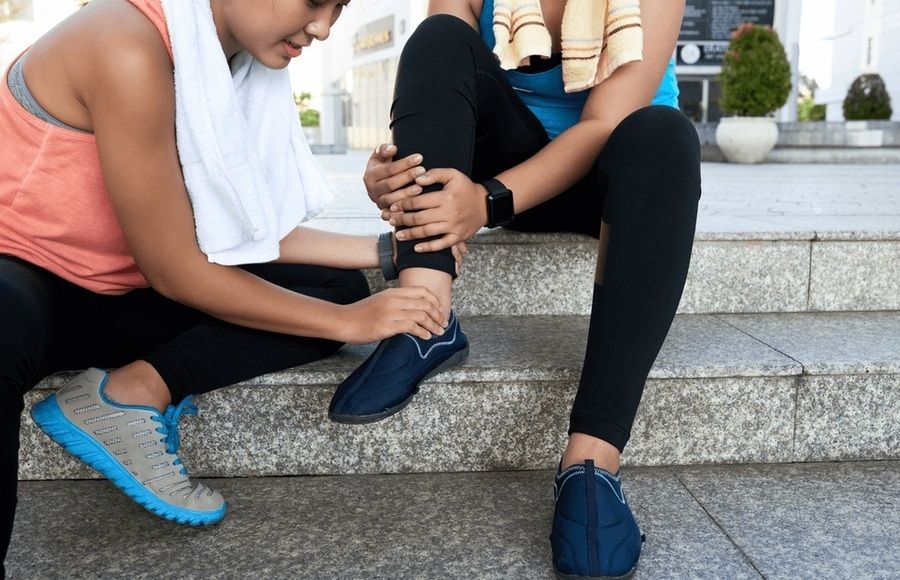 Person helping a friend with an ankle injury after exercise, seeking care from the best orthopedic surgeon in San Francisco.