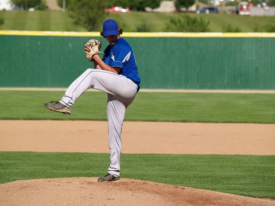 Baseball pitcher on the mount winds up to pitch