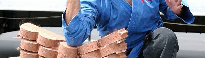 man breaking brick with his elbow