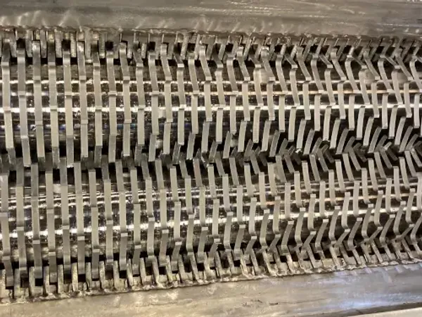 A closeup of the cutter teeth inside of a shredder
