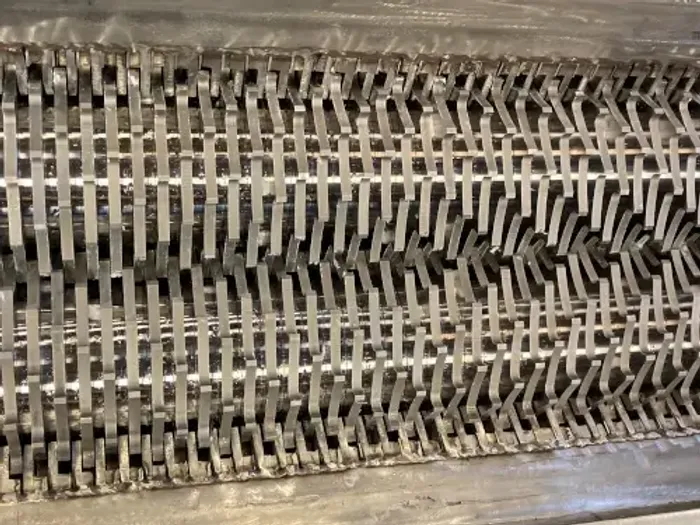 A closeup of the cutter teeth inside of a shredder