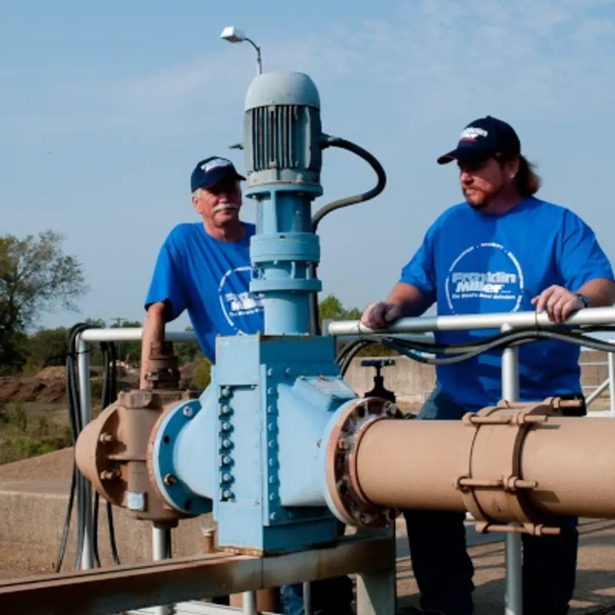men with taskmaster grinder outside