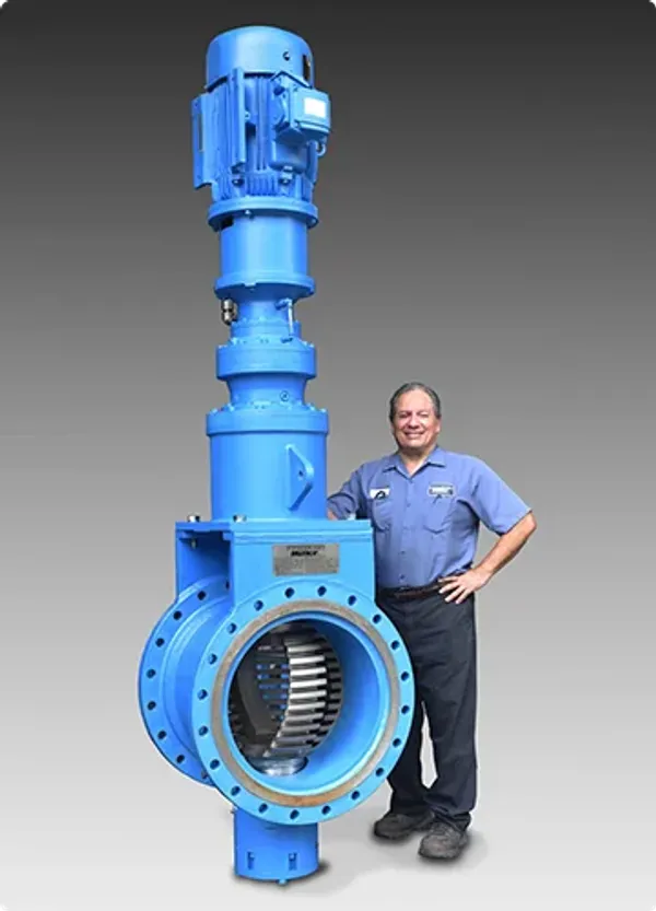 A man standing next to a large industrial grinder