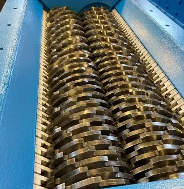 A closeup of the cutter teeth inside of an industrial shredder