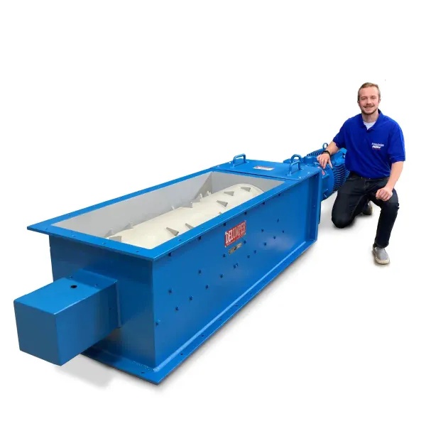 A man kneeling next to a large industrial crusher