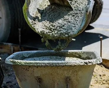 A cement mixer dumping cement into a wheelbarrow