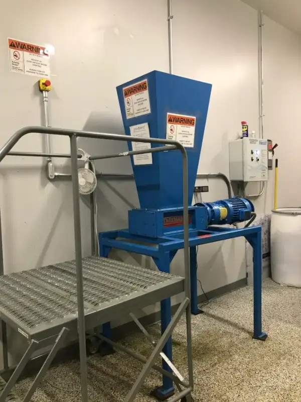 A large industrial shredder set up in a warehouse prepared for cannabis shredding