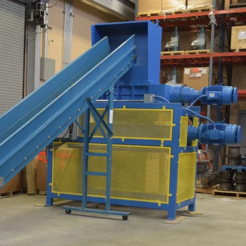 A twin shaft shredder with a conveyor attachment installed in at warehouse