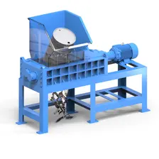TASKMASTER TM3042 dual-shaft shredder with a steel drum in its feed hopper and shredded metal output falling beneath the cutting chamber