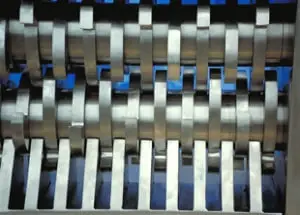 A closeup of the cutting teeth inside of an industrial shredder