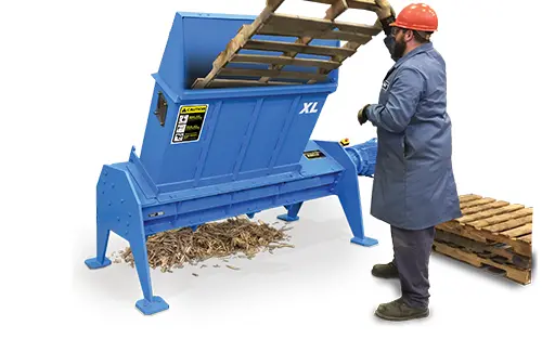 man shredding pallet in blue machine