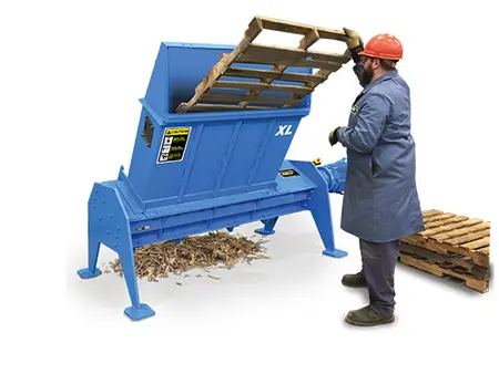 man shredding pallet in blue machine