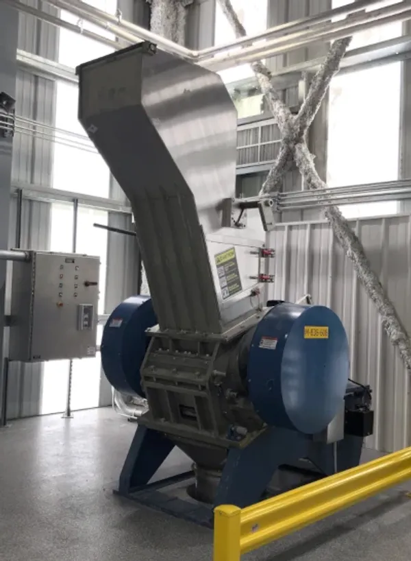 An industrial rubber granulator sitting in a warehouse