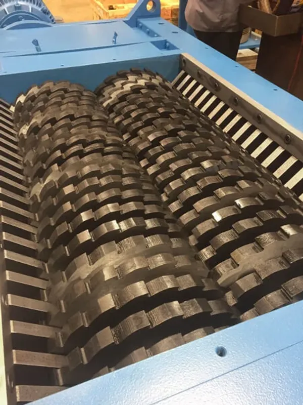 A closeup of the cutter teeth inside of an industrial shredder