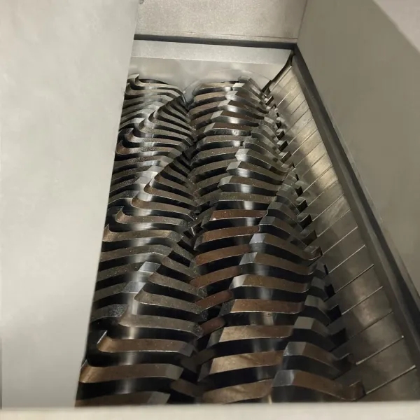 A closeup of the cutter teeth inside of an industrial shredder