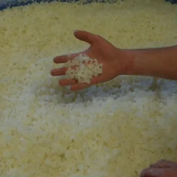 A hand holding small rubber granules