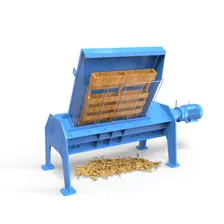 TASKMASTER XL12 pallet shredder with a wooden pallet in its feed hopper and a pile of wood chip output on the floor beneath