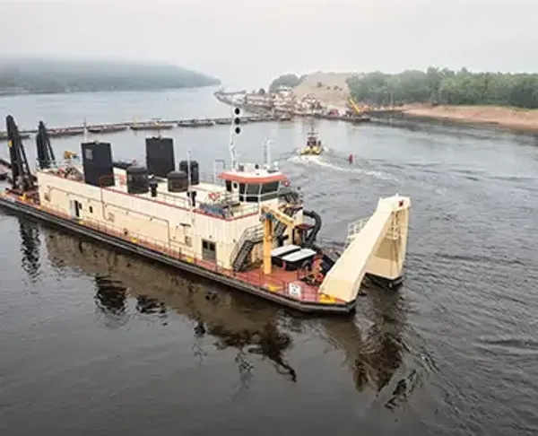 A large dredging ship sailing down a body of water