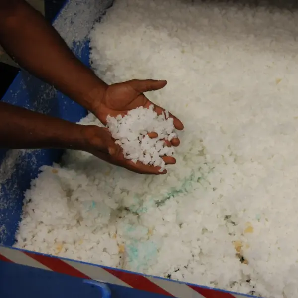 Two hands holding shredded rubber pieces